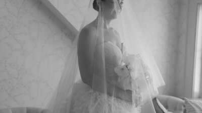 Black and white close up photo of a bride with a veil and bouquet