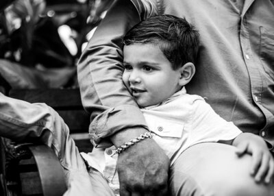 Black and white photo of little boy and his grand father hugging, sitting down