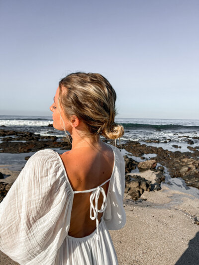 spiritual woman on beach in white dress