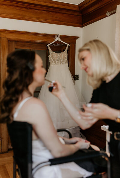 Yana adding final touch-up to bride’s makeup before ceremony in San Francisco wedding venue.

