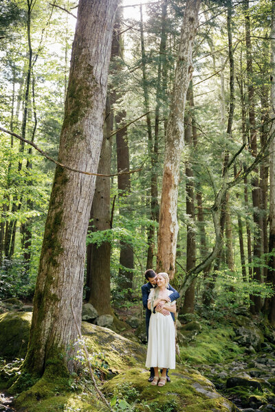 Smoky Mountain elopement at Spence Cabin with groom standing behind his bride and holding her around her shoulder and smiling down at her