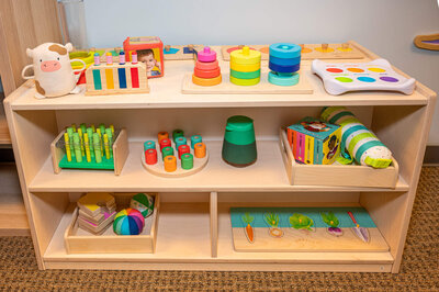 Wooden shelf at Hartbeeps in Westport,  displaying colorful wooden montessori toys.