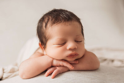 Mom snuggling newborn baby boy in a dreamy lifestyle set in harrisburg newborn photos