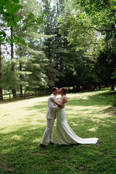 A bride and groom walking after their wedding ceremony in Austin, Texas. The bride is holding her flowers, the groom is holding her dress. 