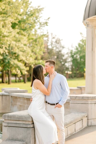 Engaged couple posing at the centerpiece at Coxhall Gardens in Carmel, IN