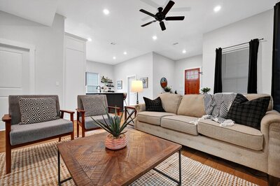 Living room with comfortable seating in this three-bedroom, two-bathroom home with fully stocked kitchen, large backyard, grill, and basketball hoop in downtown Waco, TX.