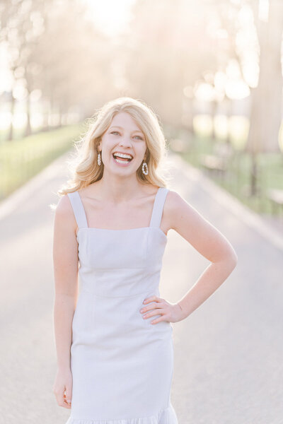 college girl laughing with arms on her hips during her senior pictures in Washington, DC