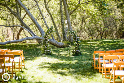 Outdoor wedding ceremony setup with floral arch and chairs