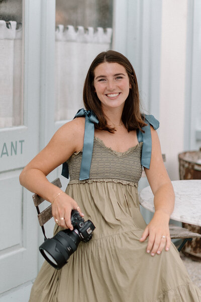 Caroline Keown, photographer, smiles ehile holding up her camera