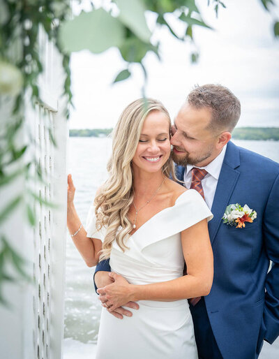 grooms holds brides face amongst flowers