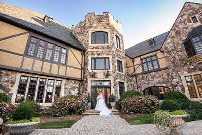 Wide-and-low-angle-bridal-portrait-on-the-front-steps-of-the-Club-at-Longview-showcasing-their-stone-architecture-and-landscaping