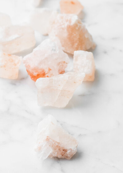 Pink Himalayan salt crystals on a marble surface.
