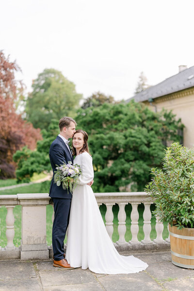 Svatební fotografie novomaželů u zábradli v parku zámku čechy pod kosířem