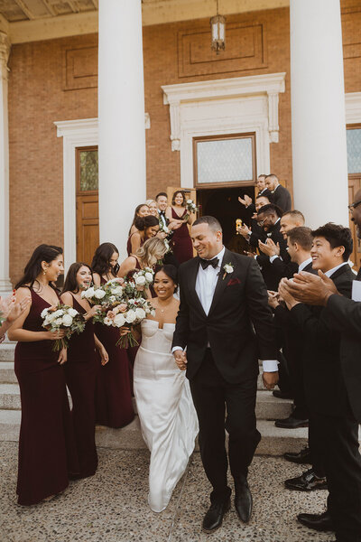 newlywed couple leaves st. aloysius church at gonzaga university after their spokane wedding