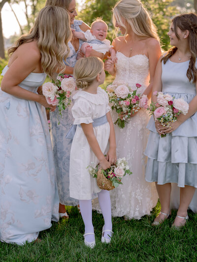 Bride smiling with bridesmaids and flower girls