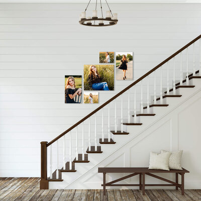 canvases of senior photos hung by staircase