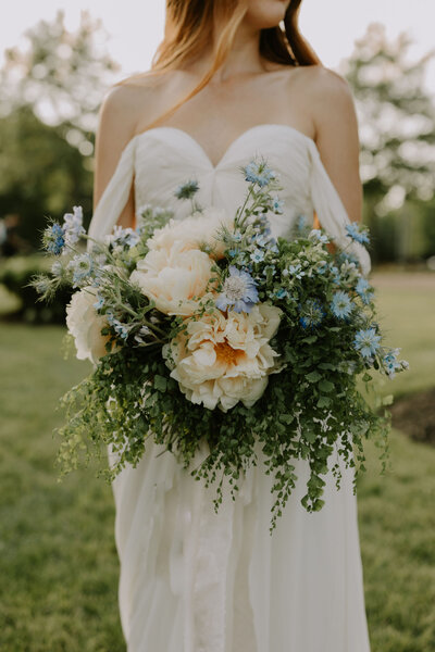 Bride holding a bouquet with peonies outdoors at an outdoor Nashville wedding