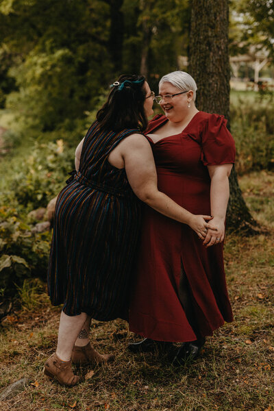 lesbian couple leaning in for a kiss smiling