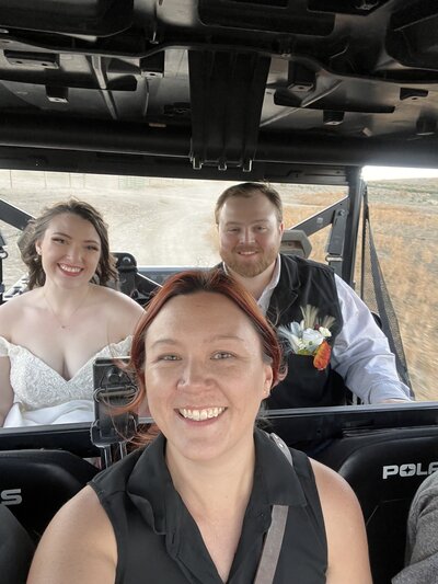 selfie of photographer and the bride and groom riding in a side by side