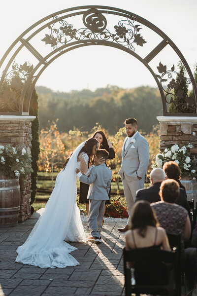 Child of the bride hugs her mother before the wedding ceremony
