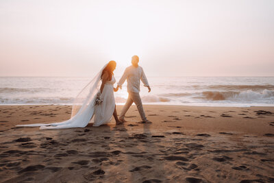 A couple walking on the beach for their bridal session.