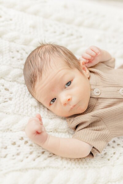 baby sleeps on bed during in home newborn photo session with Sara Sniderman Photography in Natick Massachusetts