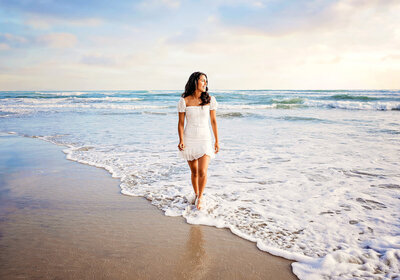 San Diego Senior Photographer, Tristan Quigley, features a beautiful senior girl walking in the ocean during her photography session at the beach