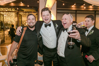 Brian Johnson, Nashville wedding videographer and owner of With This Ring Wedding Films + Photo, smiling and giving a thumbs up beside a piano during a wedding reception.
