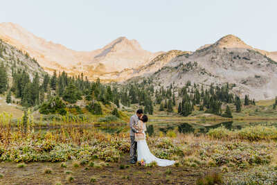 A bride and groom kisses in front of a scenic mountain backdrop during their adventure elopement in Crested Butte, Colorado.