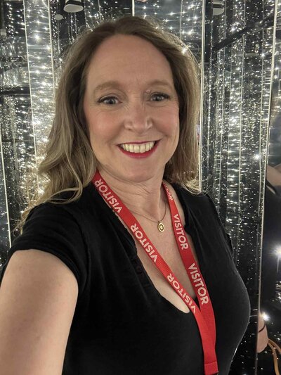 Terra Brown with Adventures by Terra standing in black shirt in the sparkling Manor hallway onboard Virgin Voyages ship