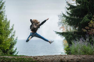 A woman captured mid-air in a jump shot, showcasing a moment of dynamic energy and vitality