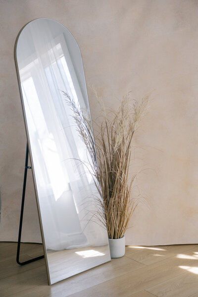 Handpainted cream background surrounded by a natural grass pot and a stand up mirror in the Natural Light Studio