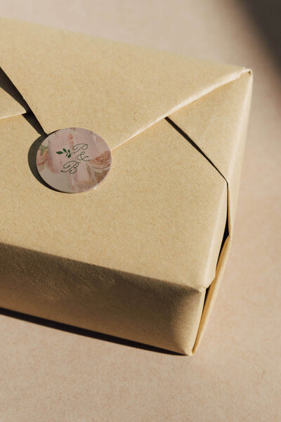 a package wrapped in craft paper with a floral sticker