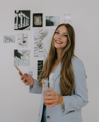 showit branding and website designer​ Palme Design Co holding her phone