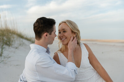 Man caressing woman's face taken by florida engagement photographers