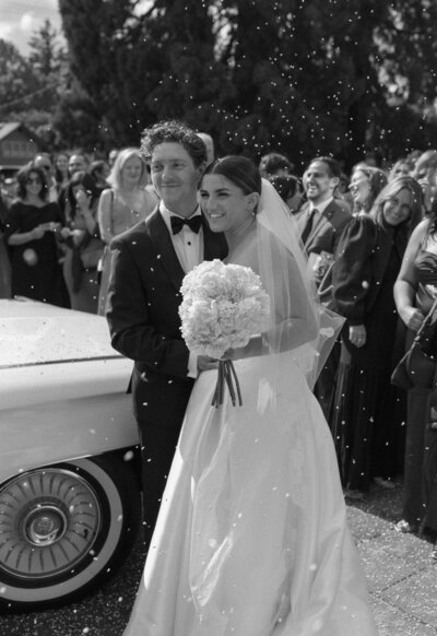 black and white photo of bride and groom with bird seed