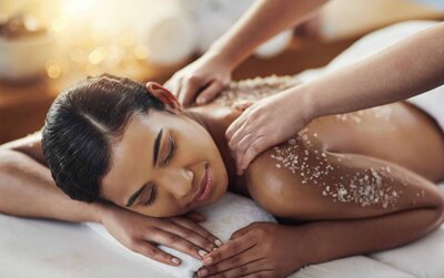 Heart-shaped Himalayan salt stones are lined up on coarse pink salt crystals, creating a textured, natural background with warm earthy tones—perfect for massage therapy sessions in Tolleson, Arizona.