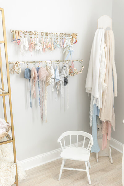 rack of newborn headbands, bows and swaddles in studio