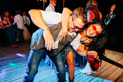 Groom laughing with guest on dance floor at Cattle Springs in Arlee, MT