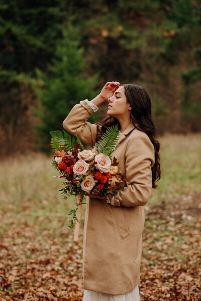 woman holding bouquet in forest