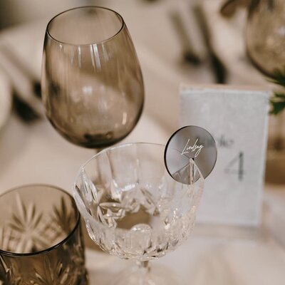 Silver metallic round acrylic custom-engraved guest drink tags.