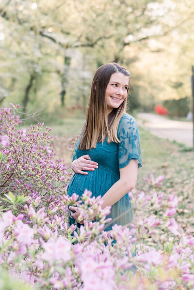 pregnant woman holding stomach in flowers