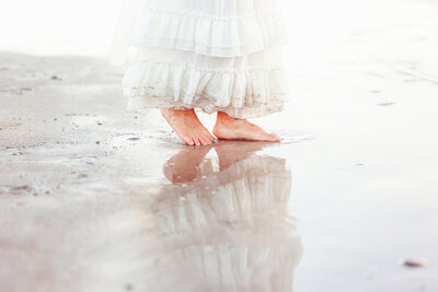 Close up of young girls feet and reflection in the sand while playing with local Fresno photographer in Avila Beach, CA