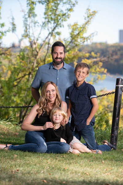 Family of 4 outside government house  with Saskatchewan river behind them