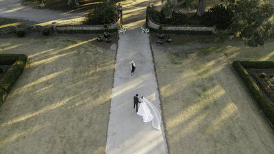 drone photo of bride and groom recessing out of their wedding ceremony at boone hall
