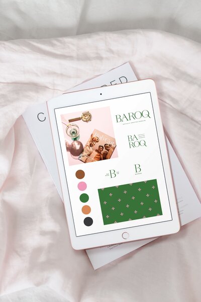 An iPad is sitting on top of a magazine showing an elegant, romantic style brand design, color palette, brand pattern, and logos.