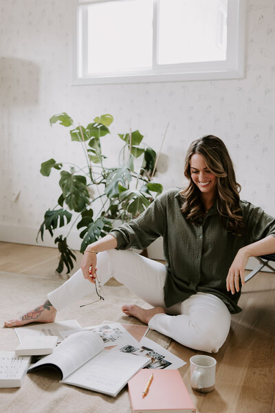 Website copywriter Erika Fitzgerald sitting on the floor with a magazine