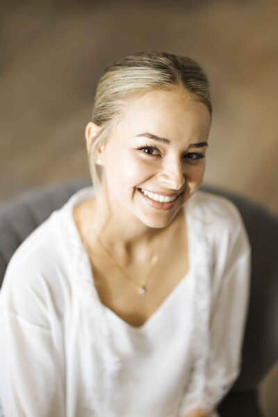 Bride smiling at the camera while getting ready for wedding
