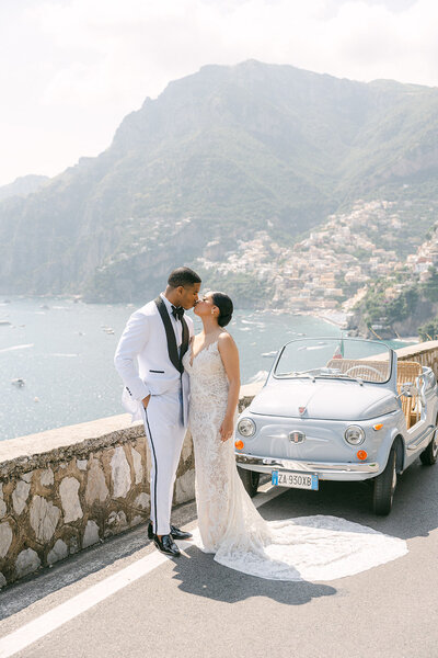 bride and groom kiss on bridge in Positano