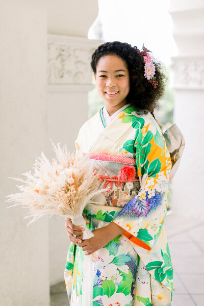Young woman smiling in colorful furisode kimono for Seijinshiki (成人式) coming-of-age ceremony.